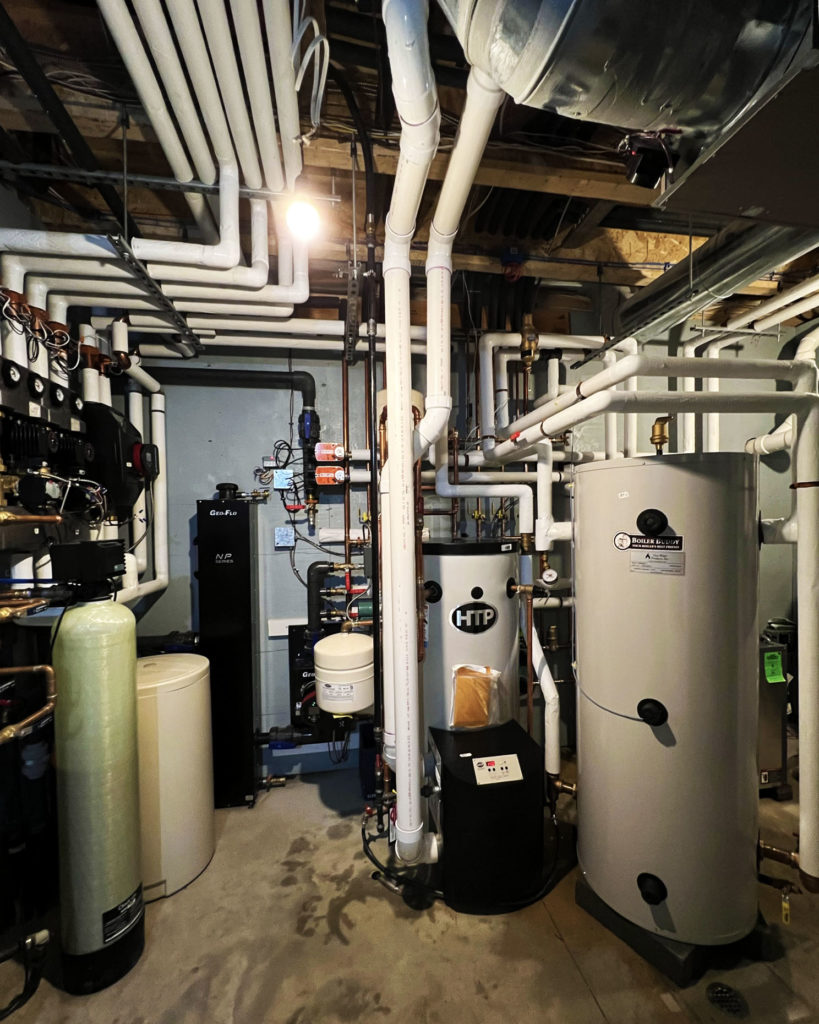 Mechanical room supporting hydronic cooling and heating via radiant floors and fan coils.