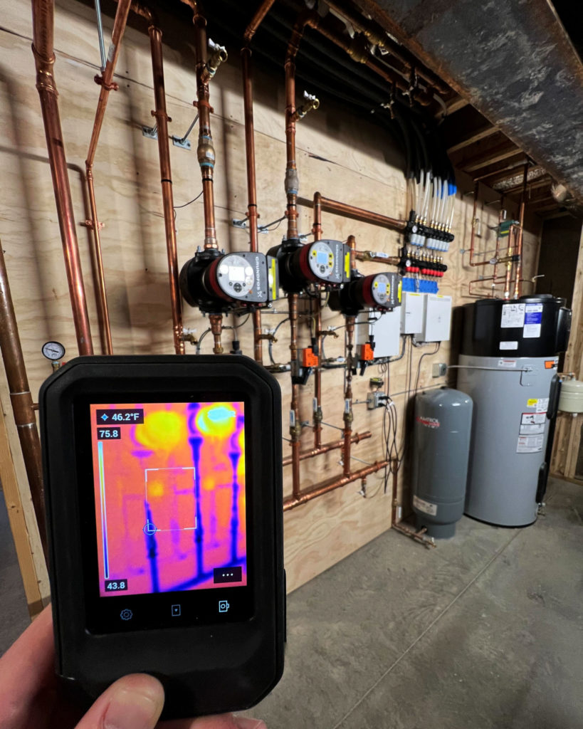 Mechanical room that utilizes two geothermal heat pumps to provide hydronic heating and cooling.