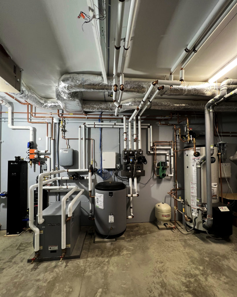 Mechanical room used to provide hydronic heating and cooling via a radiant ceiling, radiant floor, and hydronic fan coils.