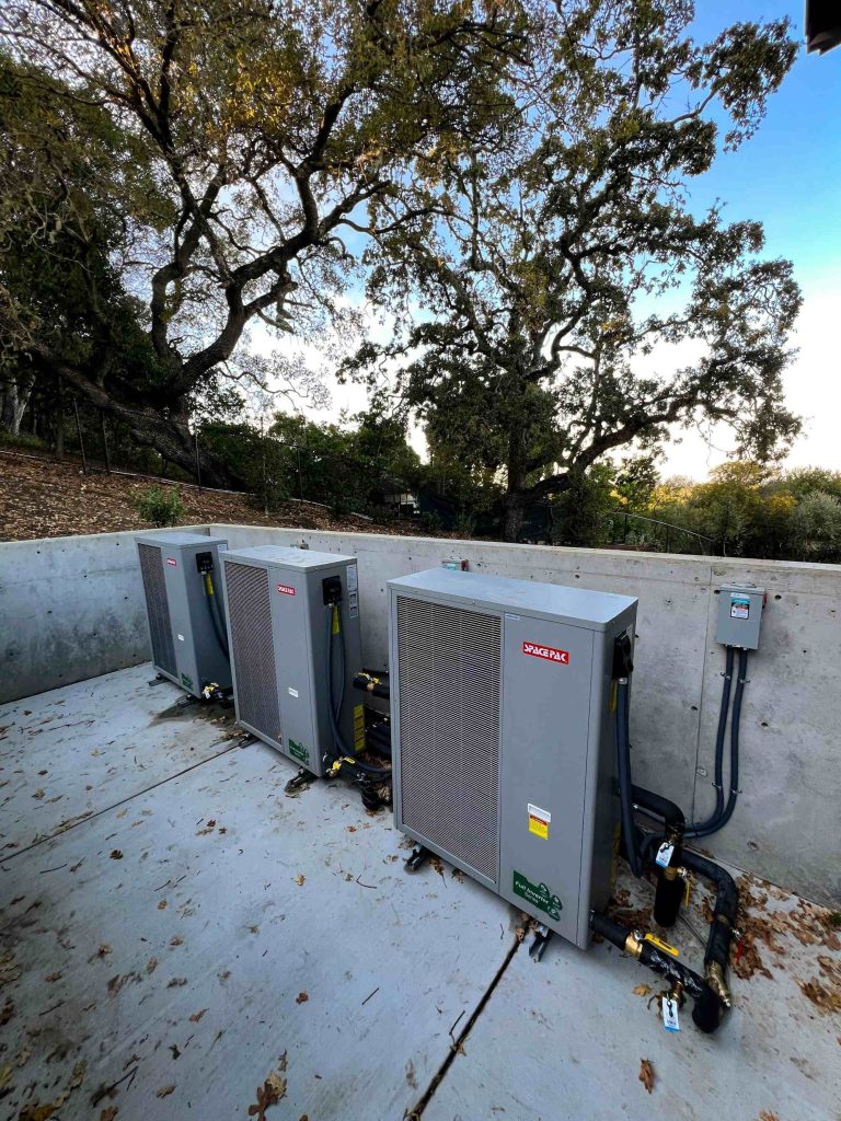 Three 5-ton SpacePak air-to-water heat pumps, generating heated and chilled water for radiant floor heating and cooling. The heat pumps are staged using a cascade method to optimize efficiency.