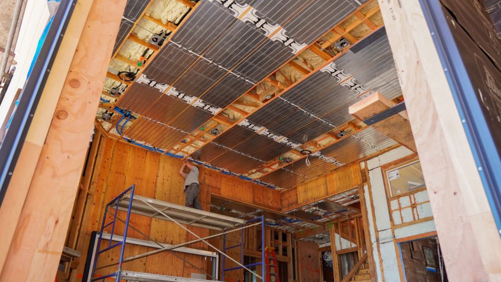 Hydronica, Inc. installer insulating PEX piping for the hydronic radiant ceiling system.